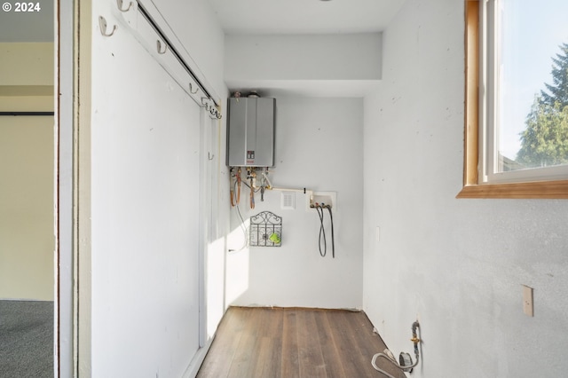 washroom with dark wood-type flooring and tankless water heater