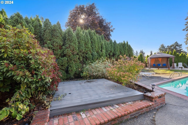 exterior space featuring a gazebo, a patio area, and a wooden deck