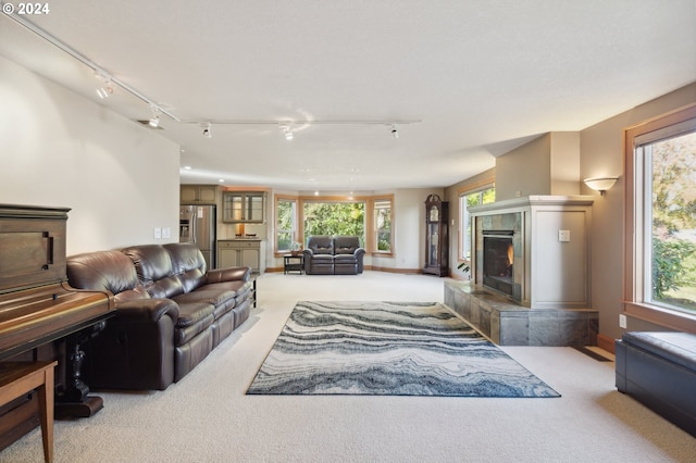 carpeted living room with track lighting and a fireplace