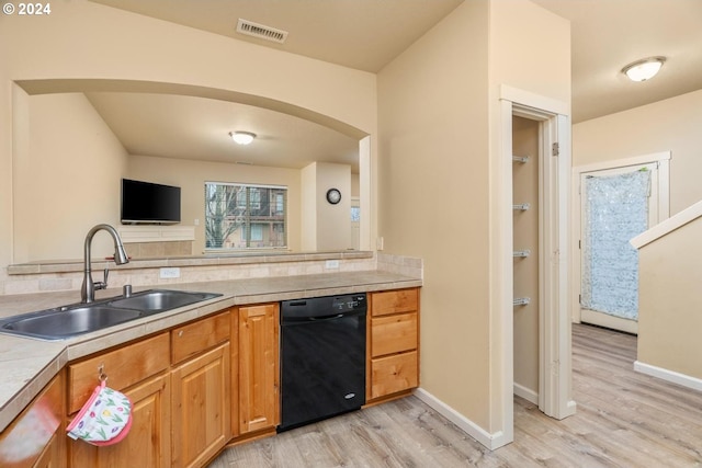 kitchen featuring dishwasher, light wood-type flooring, and sink