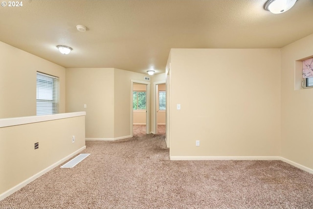 carpeted empty room with a textured ceiling