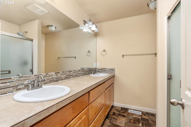 bathroom with decorative backsplash, vanity, and an enclosed shower