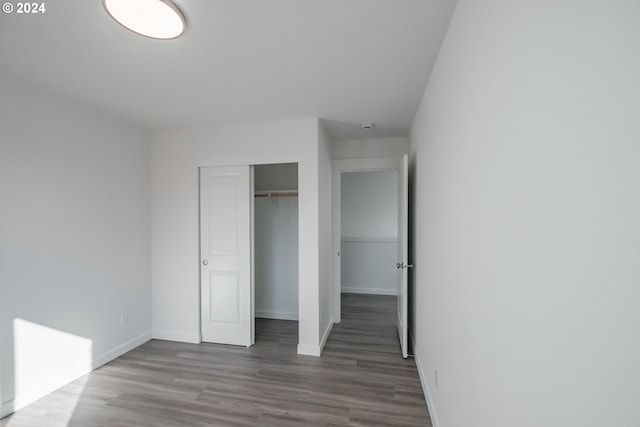 unfurnished bedroom with a closet and hardwood / wood-style floors