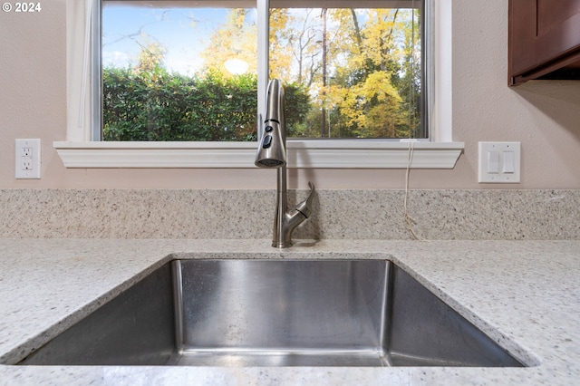 room details with light stone countertops and sink