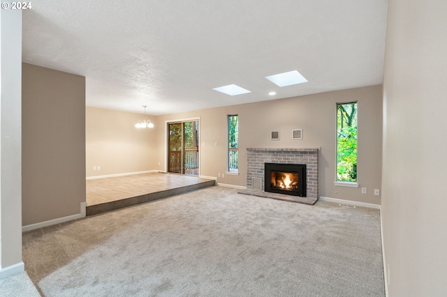 unfurnished living room featuring light carpet, a brick fireplace, and a notable chandelier