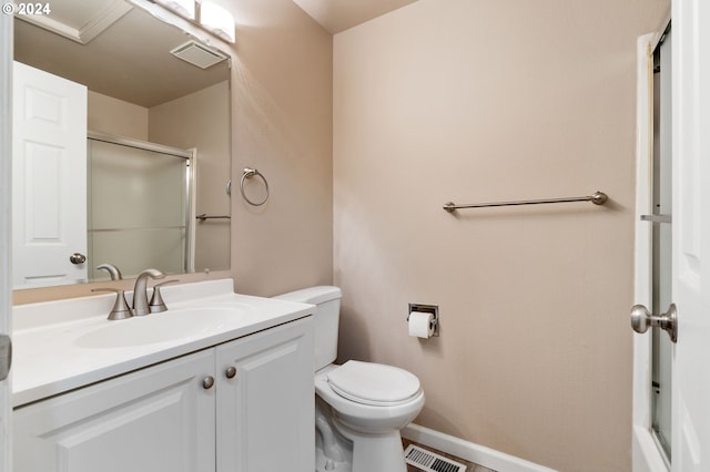 bathroom featuring an enclosed shower, vanity, and toilet