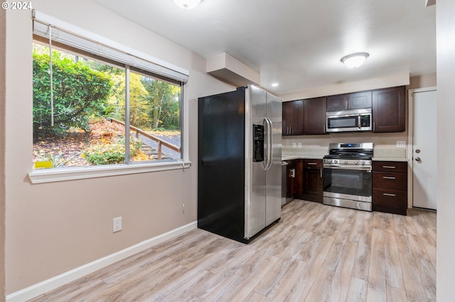 kitchen featuring dark brown cabinetry, light hardwood / wood-style flooring, and appliances with stainless steel finishes