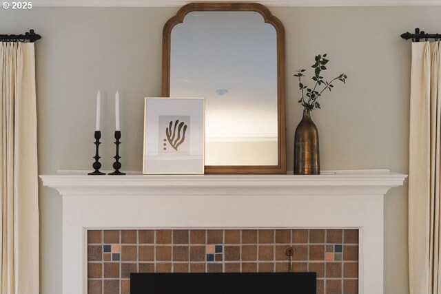 living room with crown molding, a tiled fireplace, and light hardwood / wood-style floors