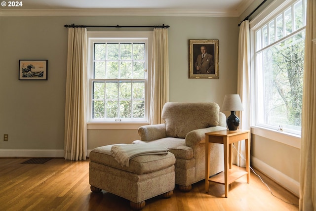 sitting room with hardwood / wood-style flooring, crown molding, and plenty of natural light