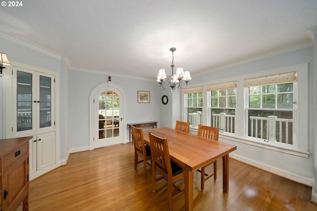 dining area with hardwood / wood-style flooring, a notable chandelier, and ornamental molding