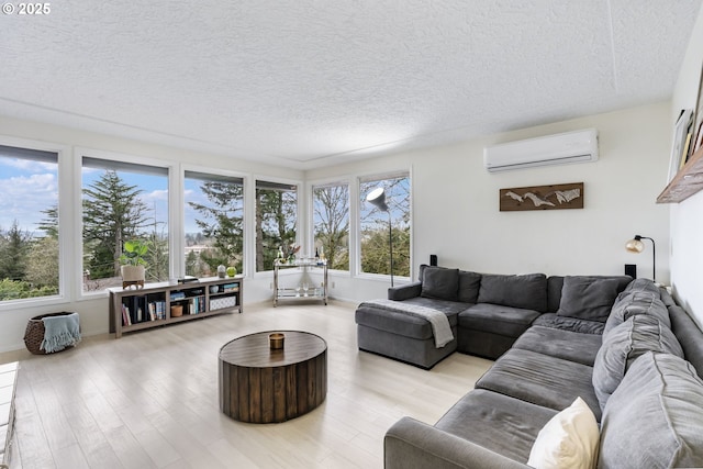 living room with a textured ceiling, a wall unit AC, and wood finished floors