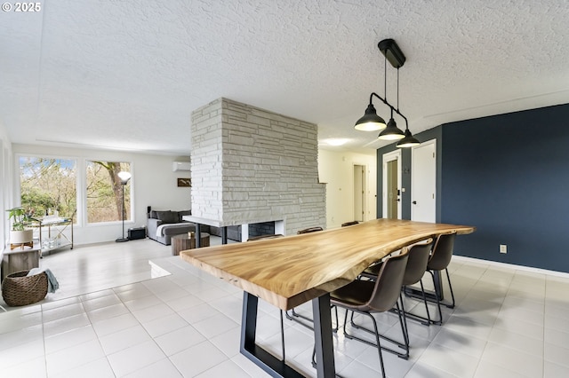 dining space with a stone fireplace, a textured ceiling, a wall mounted AC, and baseboards