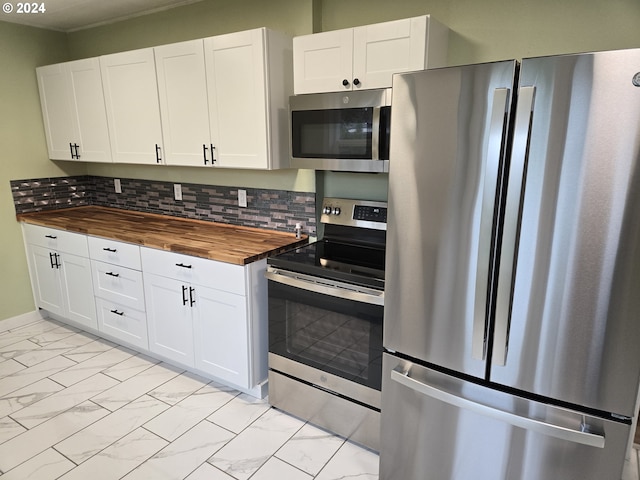 kitchen with appliances with stainless steel finishes, white cabinetry, wooden counters, and tasteful backsplash