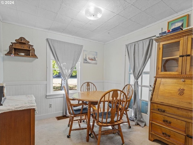 carpeted dining area featuring crown molding