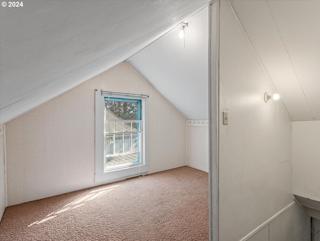 additional living space with lofted ceiling and carpet flooring