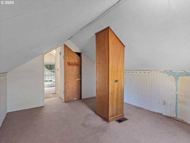 bonus room featuring vaulted ceiling and light colored carpet