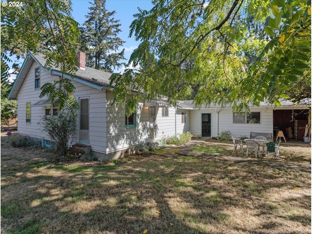 rear view of property with a yard