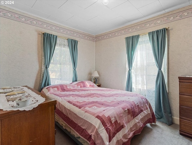 carpeted bedroom featuring multiple windows