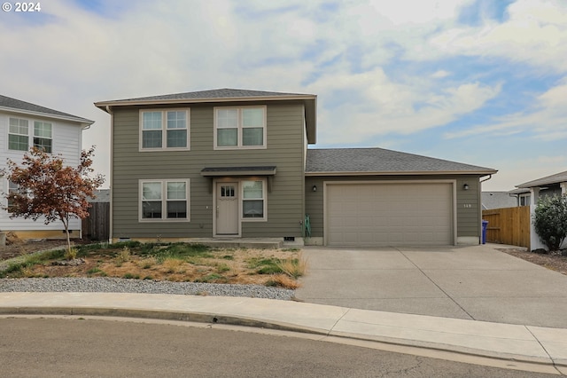 traditional-style home featuring concrete driveway, an attached garage, and fence