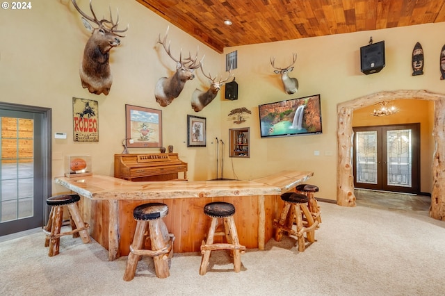 bar featuring high vaulted ceiling, carpet floors, french doors, and wooden ceiling