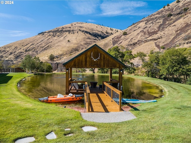 view of dock featuring a yard and a water and mountain view