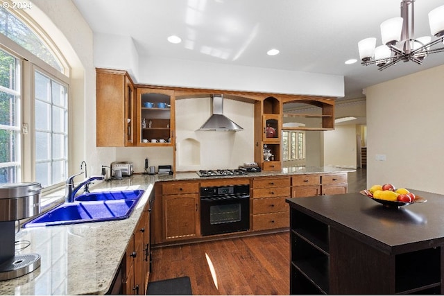 kitchen featuring sink, oven, hanging light fixtures, dark wood-type flooring, and wall chimney exhaust hood