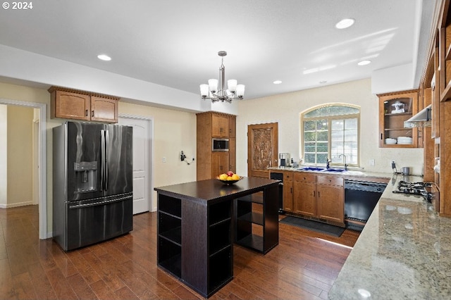 kitchen with dark wood-type flooring, sink, light stone counters, stainless steel fridge, and black dishwasher