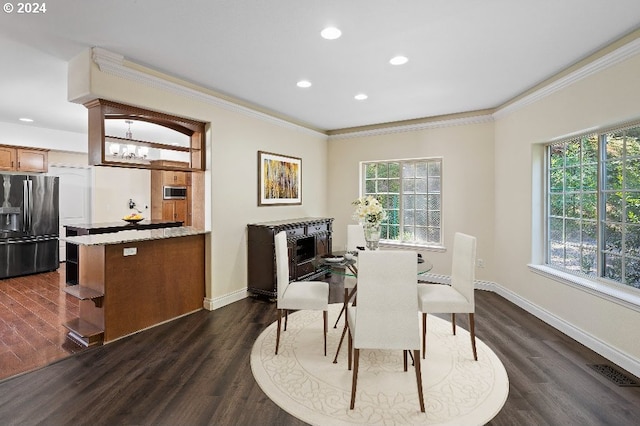 dining room with ornamental molding, dark hardwood / wood-style floors, and a chandelier