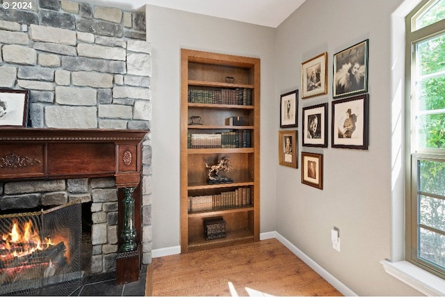 interior space featuring built in shelves, a fireplace, and hardwood / wood-style flooring