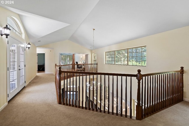 hall featuring light carpet, vaulted ceiling, and french doors