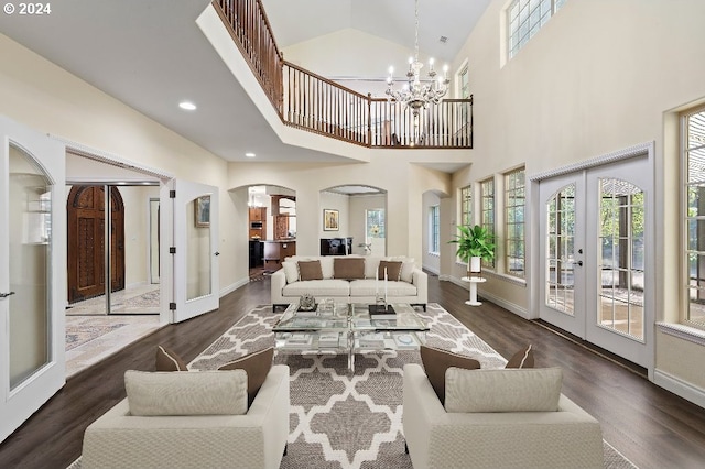 living room featuring vaulted ceiling, a notable chandelier, dark hardwood / wood-style flooring, and french doors