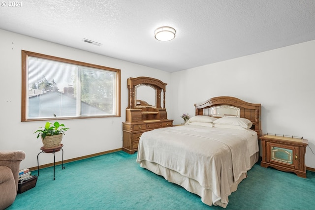 bedroom with a textured ceiling and carpet flooring