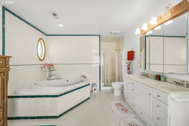 full bathroom featuring toilet, shower with separate bathtub, tile walls, vanity, and a textured ceiling