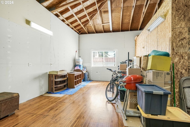 miscellaneous room featuring vaulted ceiling and wood-type flooring