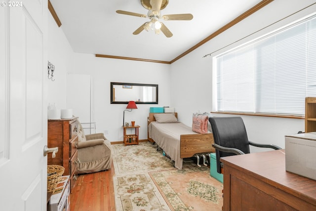 bedroom featuring light hardwood / wood-style flooring, ceiling fan, and ornamental molding