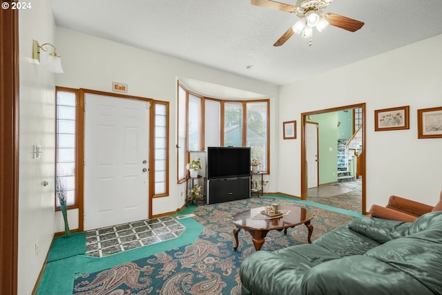 carpeted living room with ceiling fan, a wealth of natural light, and a textured ceiling