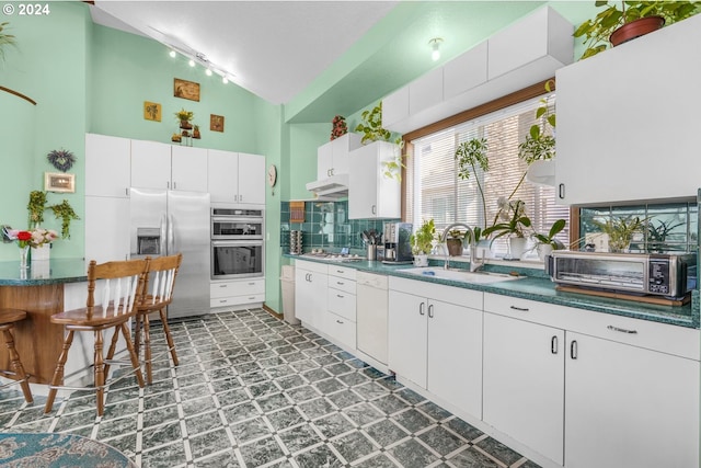 1730 SE 148th Ave, Portland, OR 97233 - kitchen featuring lofted ceiling, a sink, appliances with stainless steel finishes, tile patterned floors, and dark countertops
