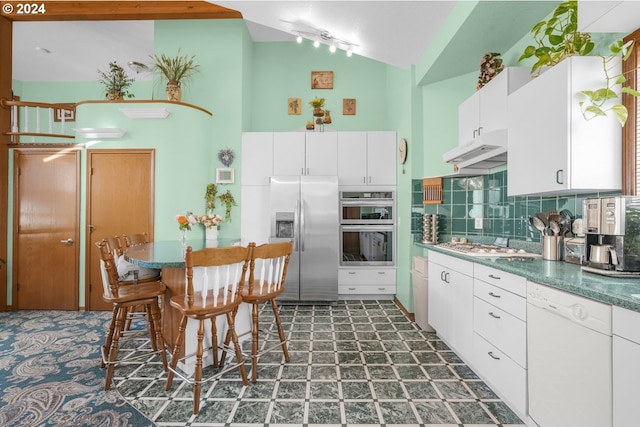 1730 SE 148th Ave, Portland, OR 97233 - kitchen featuring lofted ceiling, decorative backsplash, appliances with stainless steel finishes, white cabinetry, and under cabinet range hood