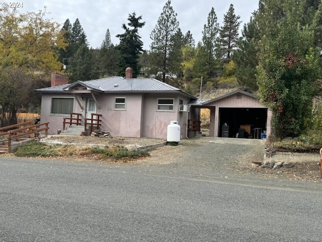 single story home featuring a garage and an outbuilding