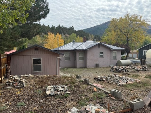 205 N Humbolt St, Canyon City, OR 97820 - view of side of property with heating fuel, a mountain view, and metal roof