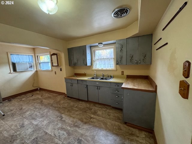 kitchen with gray cabinetry, cooling unit, and sink