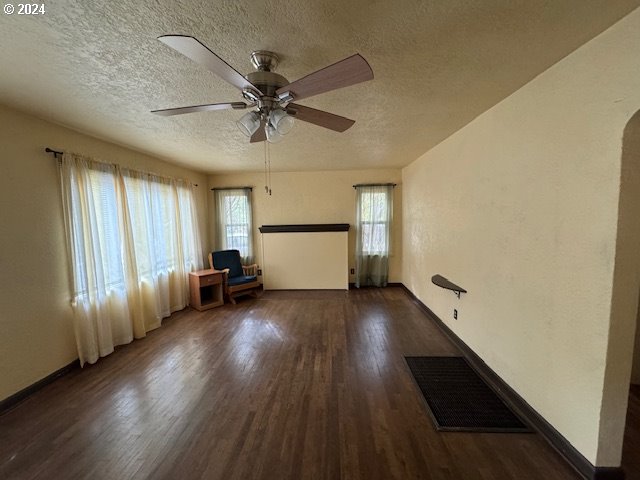 205 N Humbolt St, Canyon City, OR 97820 - empty room with a textured ceiling, baseboards, visible vents, wood finished floors, and ceiling fan