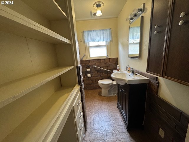 205 N Humbolt St, Canyon City, OR 97820 - bathroom featuring toilet, vanity, and wainscoting
