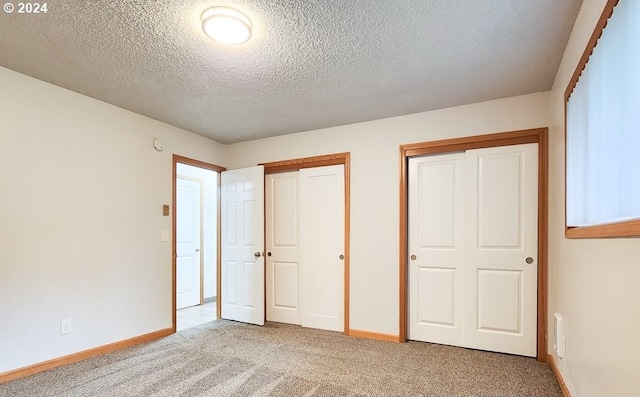 unfurnished bedroom with a textured ceiling and light colored carpet