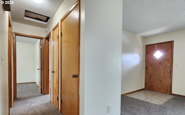 entryway with carpet and a textured ceiling