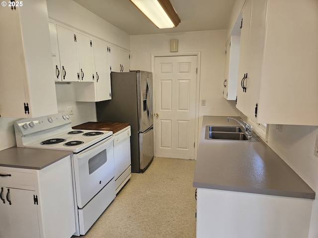kitchen with dark countertops, white cabinetry, white appliances, and a sink