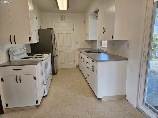 kitchen with white cabinets, a sink, and white range with electric stovetop