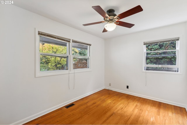 unfurnished room featuring baseboards, visible vents, ceiling fan, and light wood-style floors