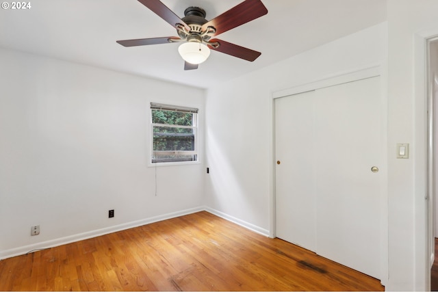 unfurnished bedroom featuring baseboards, a ceiling fan, light wood-style floors, and a closet