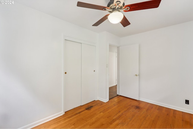 unfurnished bedroom featuring ceiling fan, baseboards, light wood-style flooring, and a closet